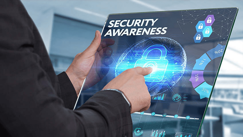 A man in a suit is pointing at a screen displaying security awareness during a Managed Security Awareness Training session.