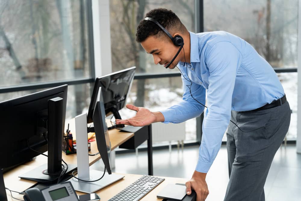 A man wearing a headset in front of a Worcester computer.