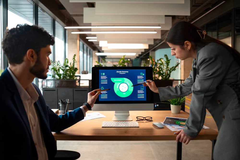 A man and woman in an office in Worcester looking at a computer screen.