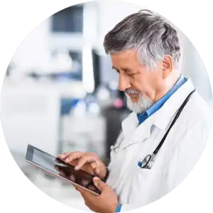 A doctor utilizing a tablet with assistance from an IT support company in a medical office.