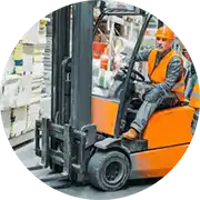 A man driving a forklift in a warehouse.