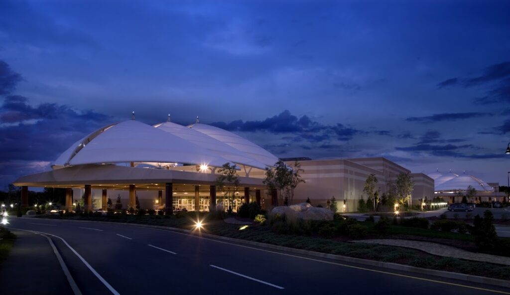 A large building with a distinctive, domed roof is lit up at night, standing as a beacon for managed IT services in North Providence. The sky is deep blue and partly cloudy, casting an ethereal glow over the empty road in the foreground.