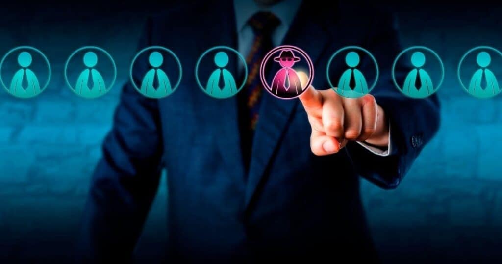 A person in a suit touches a digital screen with circles of people icons, highlighting one icon in pink.