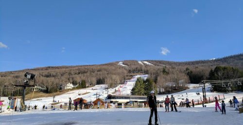 Skiers at the base of a snowy mountain, admiring the ski slopes under a clear blue sky, discussed their plans to enhance their experience with managed IT services in Durham.