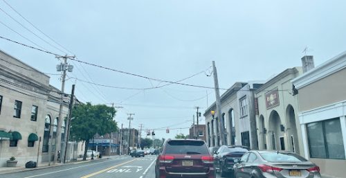 Overcast day on a suburban street with cars and managed IT services buildings in Farmingdale.