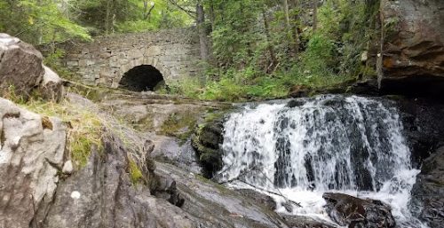 Managed IT service New Marlborough's stone bridge over a forest waterfall.