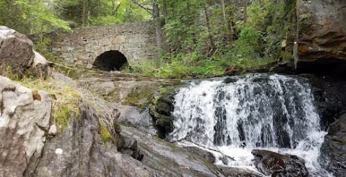 Managed IT service New Marlborough's stone bridge over a forest waterfall.
